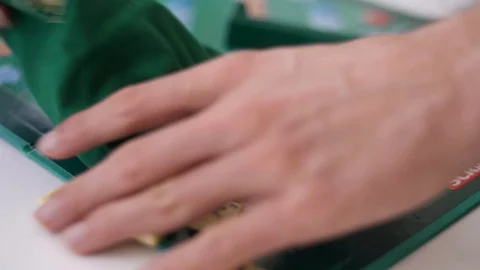 Random Scrabble game letter tiles with score value coming out of their green dra Stock Footage 126976231
