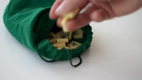Random Scrabble game letter tiles with score value coming out of their green dra Stock Footage 126976360
