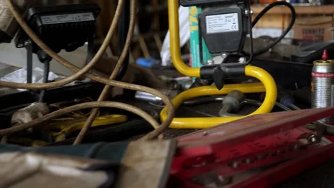 Random tools and junk sitting and hanging on workbench in old garage Stock Footage 195999478
