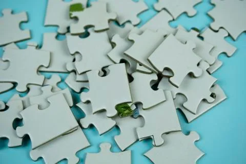 Random white jigsaw puzzle incomplete concept on blue background Stock Photos