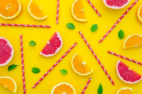 Randomly arranged on a flat lay multilple straws, sliced oranges, grapefruit and Stock Photos