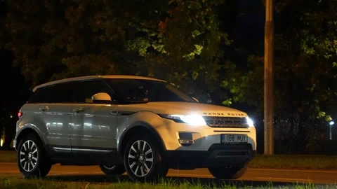 Range Rover Evoque 2015 TDi standing in the evening under rain and snow Stock Footage 310167436