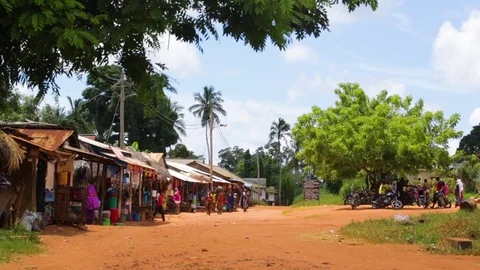 Range of shops with colorful items displayed and people roaming around Stock Footage 77446362