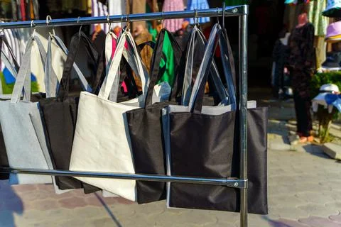 A range of square bags of different colors hang on the rack for sale Stock Photos