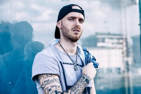 A rap singer is reflected in a blue mirror on the outskirts Stock Photos