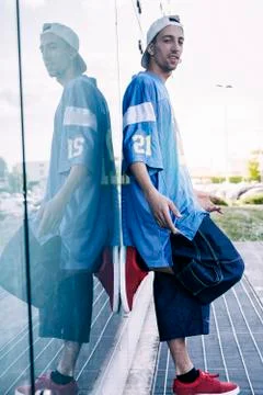 A rap singer is reflected in a blue mirror on the outskirts Stock Photos