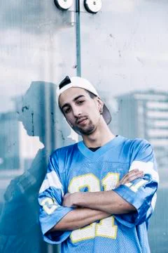 A rap singer is reflected in a blue mirror on the outskirts Stock Photos