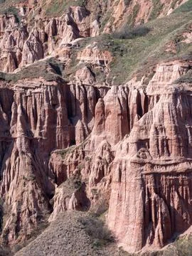 Rapa Rosie eroded cliff face with sparse vegetation Foto stock