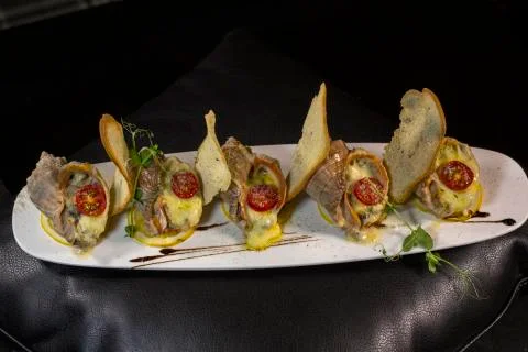 Rape baked with cheese, cherry tomato. Shellfish baked in shell. Rapane. Stock Photos