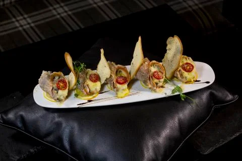 Rape baked with cheese, cherry tomato. Shellfish baked in shell. Rapane. Stock Photos