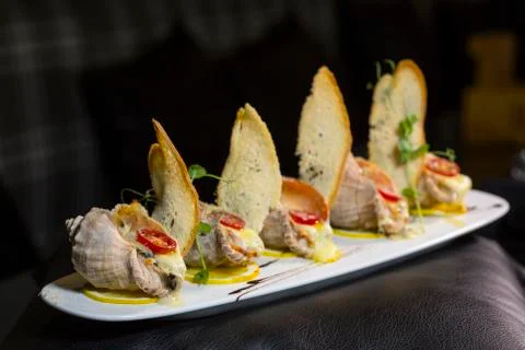Rape baked with cheese, cherry tomato. Shellfish baked in shell. Rapane. Stock Photos