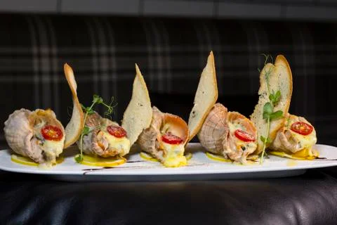 Rape baked with cheese, cherry tomato. Shellfish baked in shell. Rapane. Stock Photos