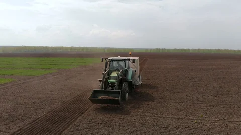 Rapeseed sowing tractor seeder selection field spring. In the background, wheat Stock Footage 129737542