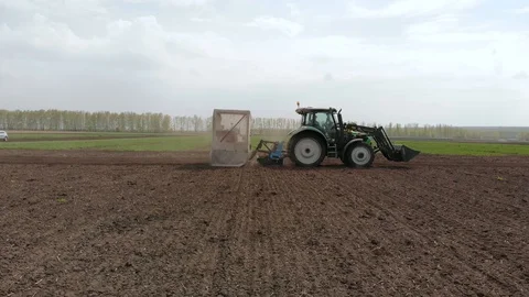 Rapeseed sowing tractor seeder selection field spring. In the background, wheat Stock Footage 129812197