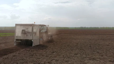 Rapeseed sowing tractor seeder selection field spring. In the background, wheat Stock Footage 129816928