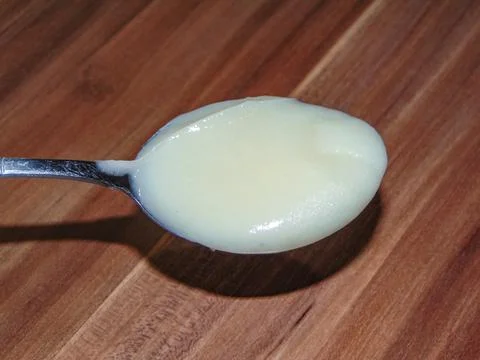 Rapessed honey on a spoon Stock Photos