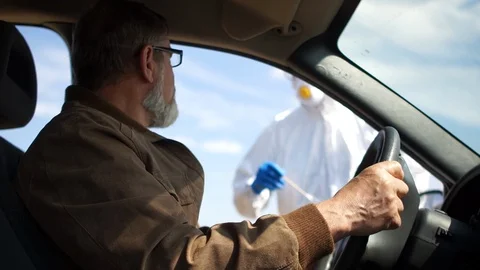 Rapid Coronavirus Testing. Coronavirus. Side view of a driver in a car. COVID19 Stock Footage 128639570