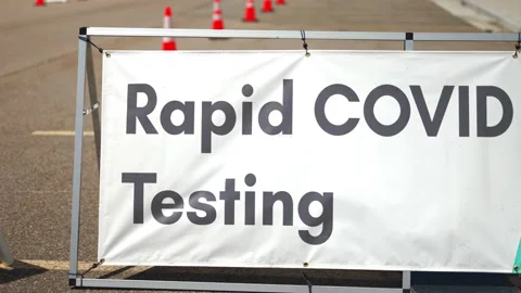 Rapid Covid-19 Testing site sign posted outside on sunny and hot summer or Stock Footage 155608980