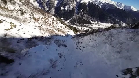 Rapid downward flight over a snowy mountain ridge Stock Footage 314417860