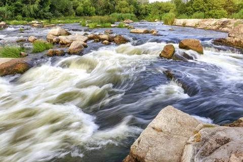 The rapid flow of the river in the blur, rocky shores, boulders and rapids,.. Stock Photos