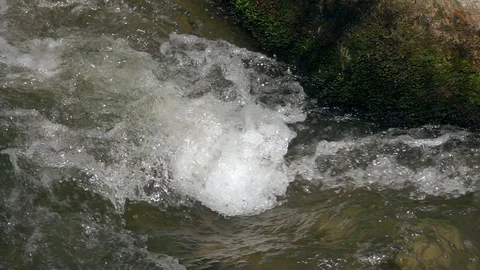 The rapid flow of the river near the stone 動画素材 106859586