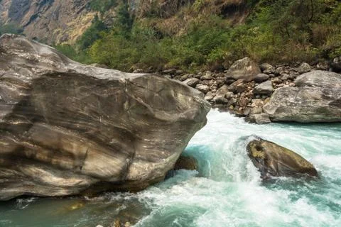 Rapid flow of water against the background of large stones. Stock Photos