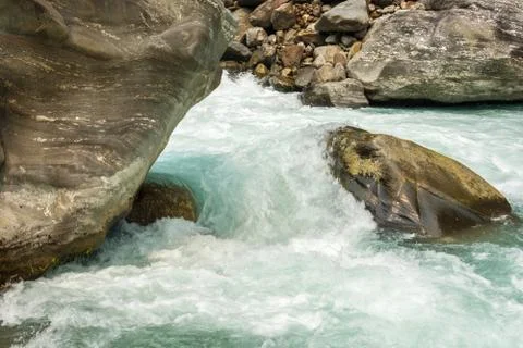 Rapid flow of water against the background of large stones. Stock Photos