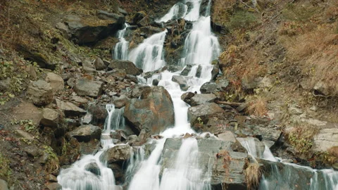 Rapid flow of water moving down a steepy slope with stones in autumn forest Stock Footage 256432676