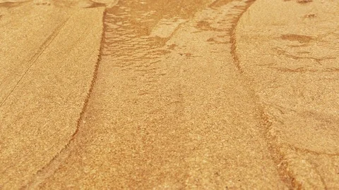 Rapid flowing water stream in fine sand bed carrying sand along, creating Stock Footage 71469152