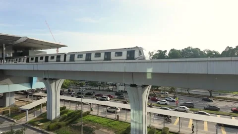 Rapid KL MRT train traveling above a busy urban roadway at Taman Midah station Stock Footage 333805553