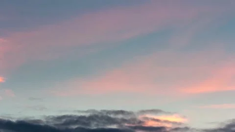Rapid movement of pink-yellow clouds in the blue sky. Stock Footage 148291816