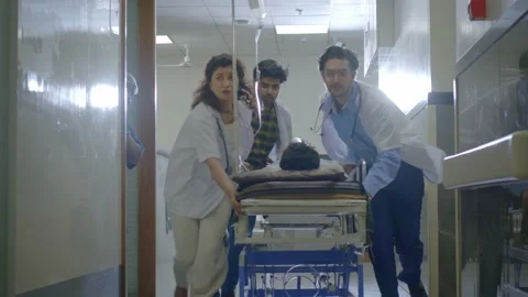 Rapid response team of doctors rushing patient on stretcher to operation theatre Stock Footage 233786910