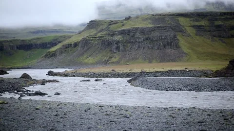 Rapid stream with black volcanic mountains in Southern Iceland Stock Footage 301251564