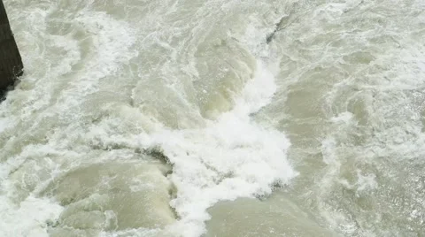 Rapid stream of muddy river beat about bridge column Stock Footage 67711945