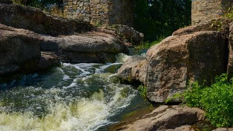 Rapid stream of summer river flowing among boulder cobble stones Stockfoto's