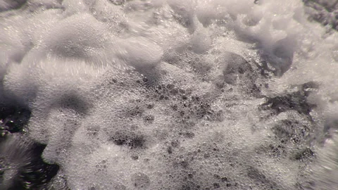 Rapid streams of foaming water splashing downstream, extreme close-up, slow Stock Footage 303338096