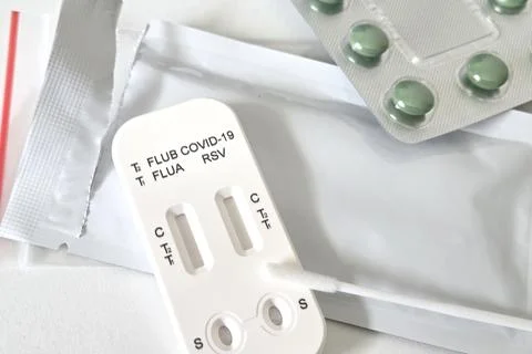 Rapid test kit for detecting flu, covid-19, and rsv, featuring a test strip a Stock Photos