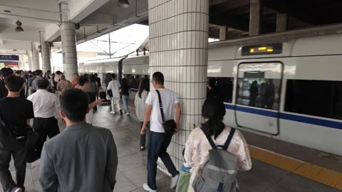 Rapid train arrival—passengers stream through platform in China Stock Footage 320564084