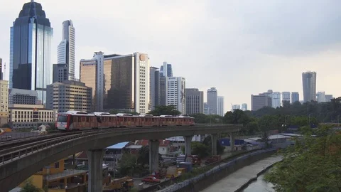 RapidKL elevated commuter train passing modern highrise buildings. Stock Footage 77139628