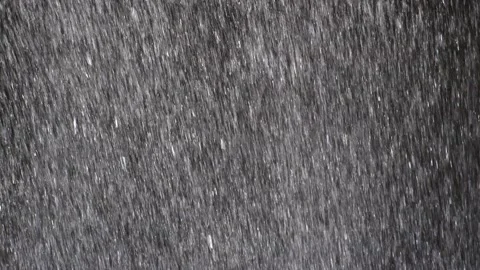 The rapidly falling water forms a wall of water droplets, solid background. Video stock 131126561