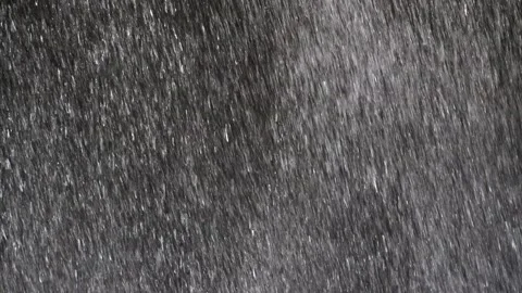 The rapidly falling water forms a wall of water droplets, solid background. Video stock 131126829