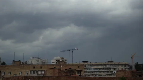 Rapidly flowing gray, ominous thunderclouds above apartment buildings with const Stock Footage 134861744