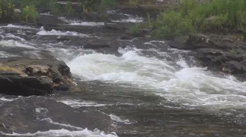 Rapids flowing past large rocks Video stock 27339149