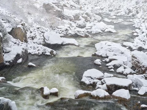 Rapids on a mountain river in heavy spring snowstorm Stock Photos