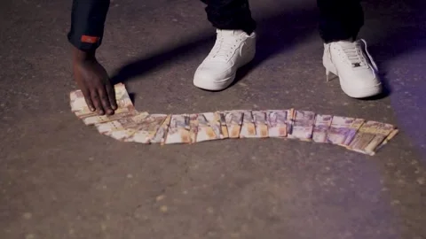 Rapper arranging thousands shilling notes on the ground 스톡 동영상 315539756