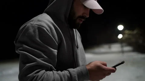 Rapper using smartphone outdoor in city park during winter night 스톡 동영상 144376854