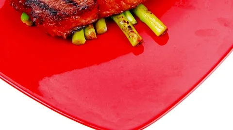 Rare medium roast beef fillet asparagus served on red dish Vídeos de archivo 45139046
