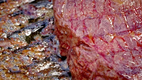 A rare piece of steak is being cooked on a hot cast iron pan. Stock Footage 317931771