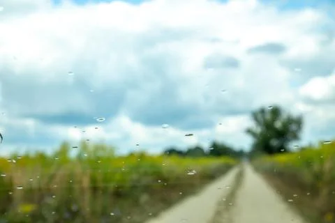 Rare raindrops on a car window with a view to rural nature landscape. Stock Photos