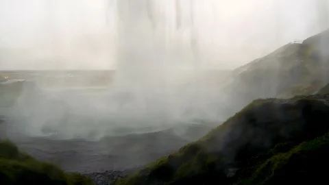 Rare unique tracking shot camera moves behind Seljalandsfoss waterfall Iceland Stock Footage 93968006
